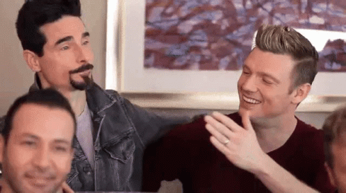 A Group Of Men Are Sitting On A Couch And Laughing Together . GIF
