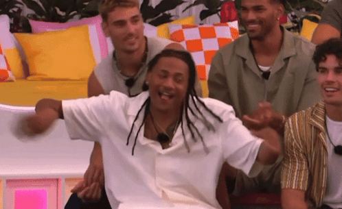 A Group Of Men Are Sitting On A Couch Laughing And Having Fun . GIF