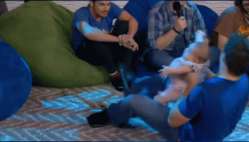 A Group Of Men Are Sitting On Bean Bag Chairs And One Of Them Is Holding A Baby . GIF