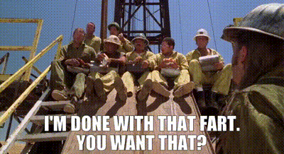 A Group Of Men Are Sitting On Top Of A Wooden Platform And A Man Is Standing In The Background . GIF