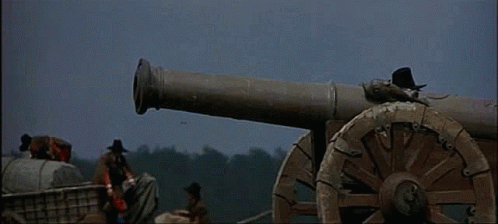 A Group Of Men Are Standing Around A Cannon That Is Firing GIF