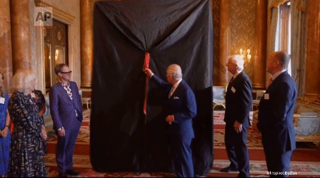 A Group Of Men Are Standing Around A Large Black Cloth That Says Ap GIF
