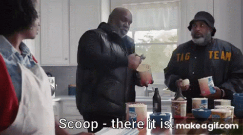 A Group Of Men Are Standing Around A Table Eating Ice Cream And Talking To Each Other In A Kitchen . GIF