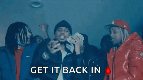 A Group Of Men Are Standing In A Dark Room With The Words " Get It Back In " On The Bottom Right GIF