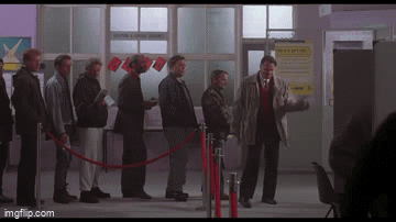 A Group Of Men Are Standing In A Line Behind A Red Rope And A Sign That Says " Moving & Storage " GIF