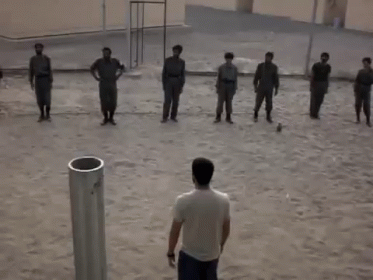 A Group Of Men Are Standing In A Line With Their Hands In The Air GIF