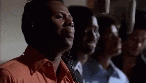 A Group Of Men Are Standing In A Room With Headphones On . GIF