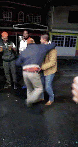 A Group Of Men Are Standing In Front Of A Building Holding Drinks GIF
