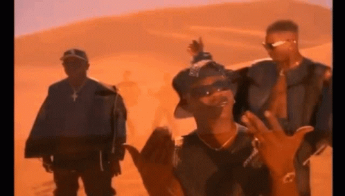 A Group Of Men Are Standing In Front Of A Desert . GIF