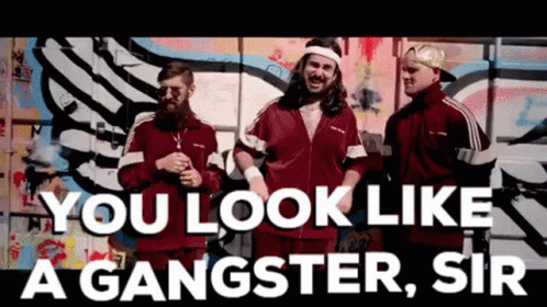 a group of men are standing in front of a graffiti wall with the words you look like a gangster sir