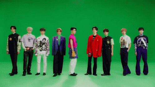 A Group Of Men Are Standing In Front Of A Green Screen . GIF