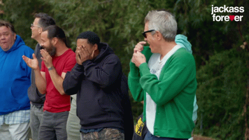 A Group Of Men Are Standing In Front Of A Jackass Forever Sign GIF