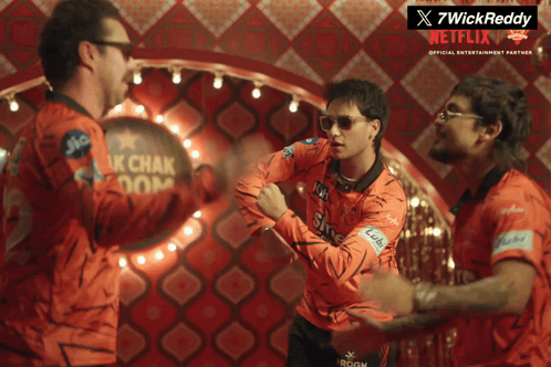 A Group Of Men Are Standing In Front Of A Netflix Sign GIF