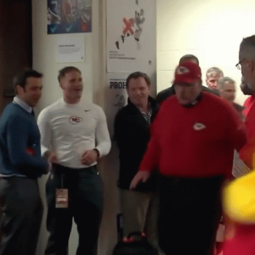 A Group Of Men Are Standing In Front Of A Wall That Has A Prof Sign On It GIF