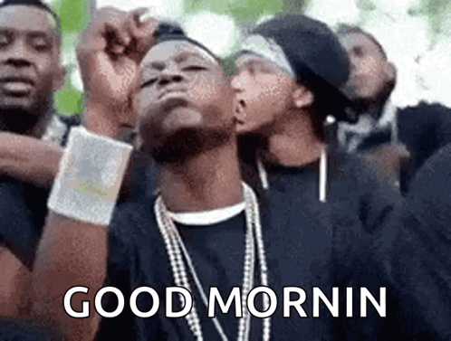 A Group Of Men Are Standing Next To Each Other And One Of Them Is Wearing A Necklace That Says `` Good Morning '' . GIF