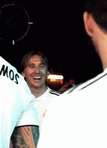 A Group Of Men Are Standing Next To Each Other In A Dark Room And Smiling . GIF