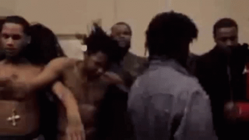 A Group Of Men Are Standing Next To Each Other In A Room Without Shirts . GIF