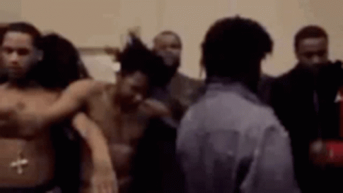 A Group Of Men Are Standing Next To Each Other In A Room Without Shirts On . GIF