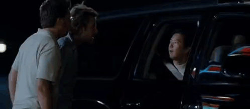 A Group Of Men Are Standing Next To Each Other In Front Of A Car With The Word Toodaloo On The Bottom . GIF