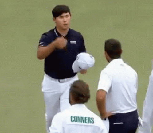 A Group Of Men Are Standing On A Golf Course And One Of Them Is Wearing A Shirt That Says Conners . GIF