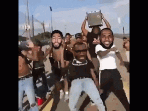 A Group Of Men Are Standing On A Street Holding A Briefcase Over Their Heads . GIF