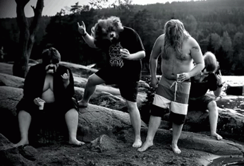 A Group Of Men Are Standing On Rocks And One Of Them Is Wearing A Shirt That Says ' King ' On It GIF