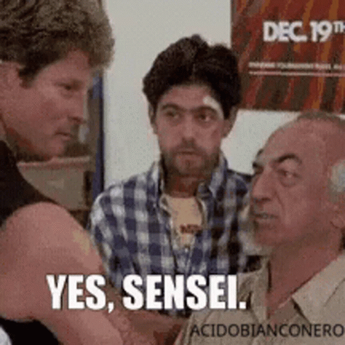 A Group Of Men Are Talking To Each Other And One Of Them Is Holding Another Man 'S Arm . GIF