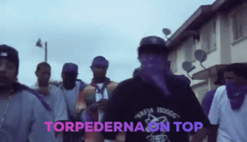 A Group Of Men Are Walking Down A Street With The Words Torpedona On Top In Pink GIF