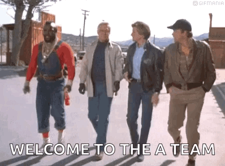 A Group Of Men Are Walking Down A Street With The Words `` Welcome To The A Team '' Written On The Sidewalk . GIF