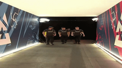 A Group Of Men Are Walking Through A Tunnel That Has A Mural On The Wall That Says Summit GIF