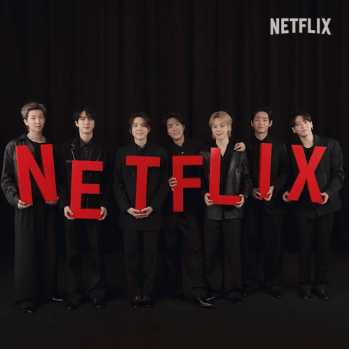 A Group Of Men Holding Red Letters That Spell Out The Word Netflix GIF