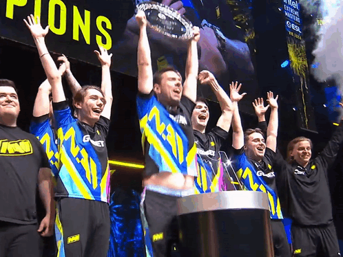 A Group Of Men Holding Up A Trophy That Says ' Champions ' On It GIF