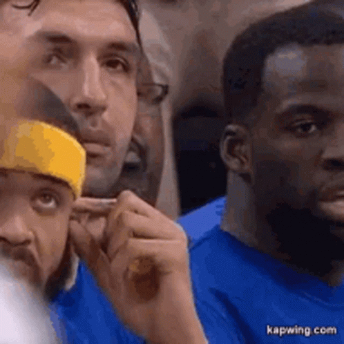 A Group Of Men In Blue Shirts Are Sitting In A Stadium . GIF