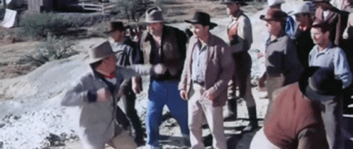 A Group Of Men In Cowboy Hats Are Standing Next To Each Other In A Field . GIF