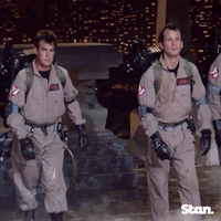 A Group Of Men In Ghostbusters Uniforms Walking GIF