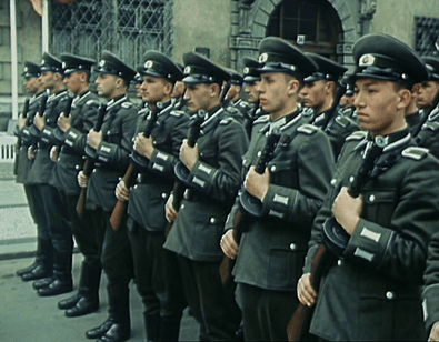 A Group Of Men In Military Uniforms Are Standing In A Line Holding Guns GIF