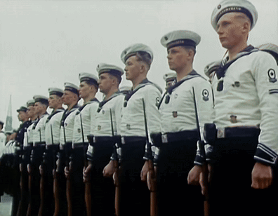 A Group Of Men In Military Uniforms Are Standing In A Row GIF