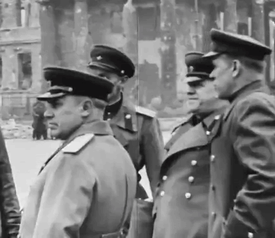 A Group Of Men In Military Uniforms Are Standing In Front Of A Building GIF