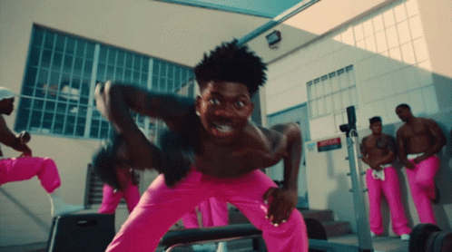 A Group Of Men In Pink Pants Are Standing In Front Of A Building GIF