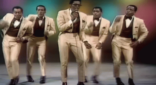 A Group Of Men In Suits And Bow Ties Are Dancing And Singing GIF