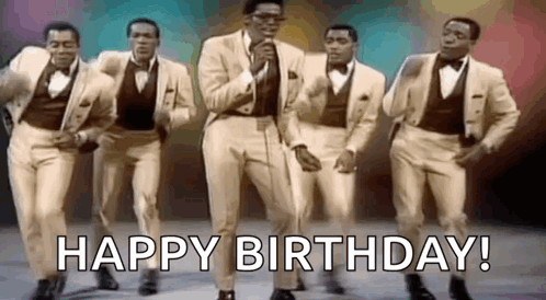 A Group Of Men In Suits And Bow Ties Are Dancing And Singing In Front Of A Microphone . GIF