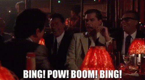 A Group Of Men In Suits And Ties Are Sitting At A Table In A Bar Talking On Their Cell Phones . GIF