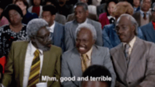 A Group Of Men In Suits And Ties Are Sitting In A Crowd And One Of Them Is Laughing And Saying Mhm Good And Terrible GIF