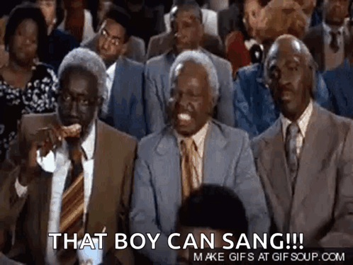 A Group Of Men In Suits And Ties Are Sitting In A Stadium . GIF