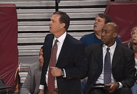 A Group Of Men In Suits And Ties Are Sitting In A Stadium Watching A Game GIF