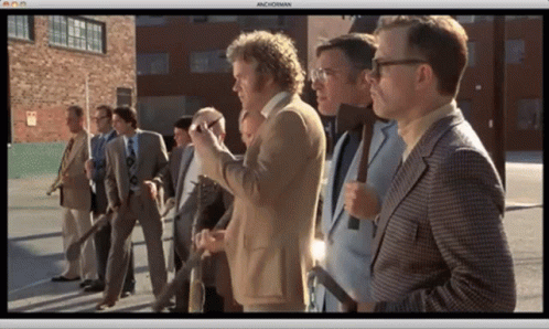 A Group Of Men In Suits And Ties Are Standing In A Row And The Screen Says Machoman GIF
