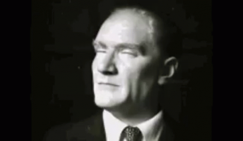 A Group Of Men In Suits And Ties Are Standing Next To Each Other In A Room . GIF