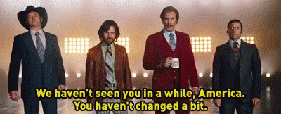 A Group Of Men In Suits And Ties Are Standing Next To Each Other In Front Of A Stage . GIF