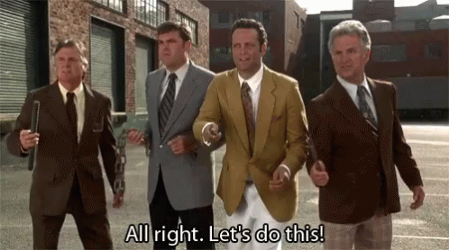 A Group Of Men In Suits And Ties Are Walking Down A Street And Saying All Right Let 'S Do This . GIF