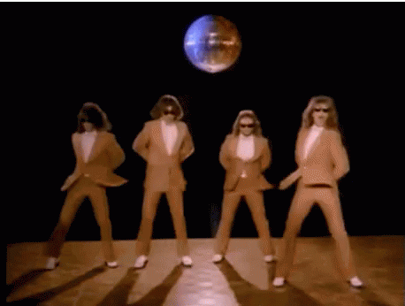 A Group Of Men In Suits And White Gloves Are Dancing In Front Of A Disco Ball . GIF